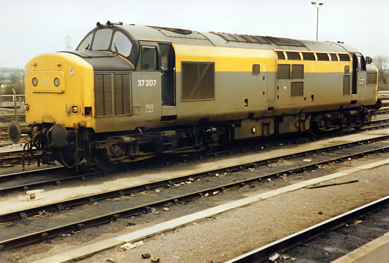 37207 in Dutch Yellow and Grey livery rests between duties at Didcot stabling point.